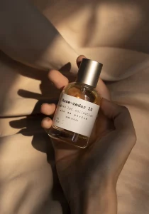 Flasche mit Rose-Cedar 10 Parfüm aus der Minimalist Collection in einer Hand gehalten.